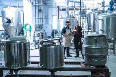 colleagues-in-brewery-standing-looking-at-clipboar-2023-11-27-05-36-27-utc